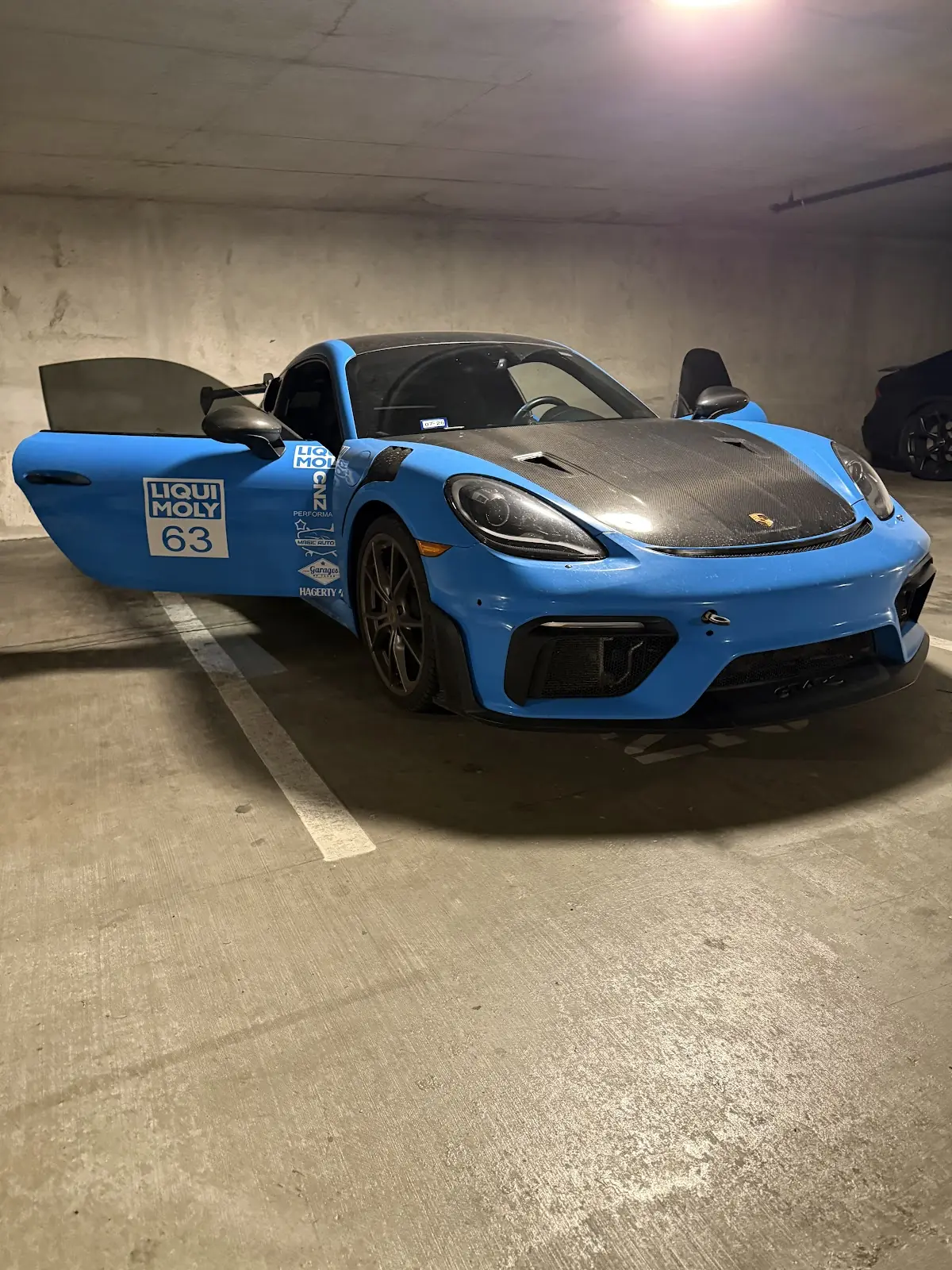 Blue sports car with doors open after a detail