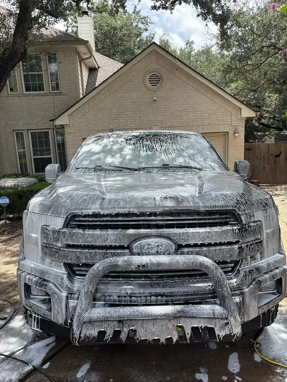 Front of a pickup truck coated in thick wash foam