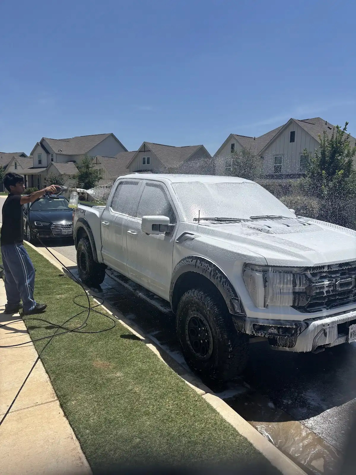 Pickup truck covered in wash foam during a mobile exterior detail