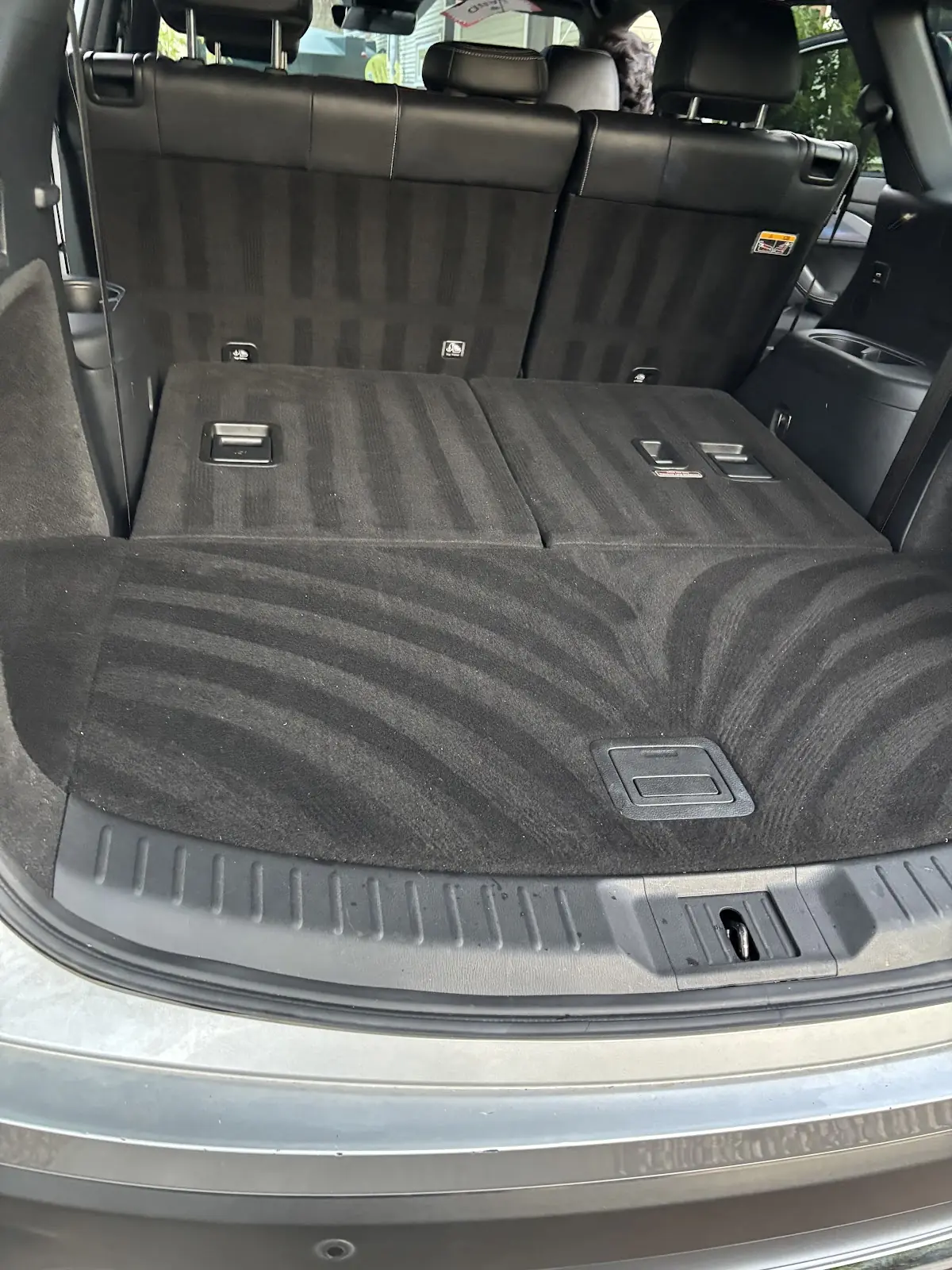 Vacuumed rear cargo carpet and folded seats in an SUV