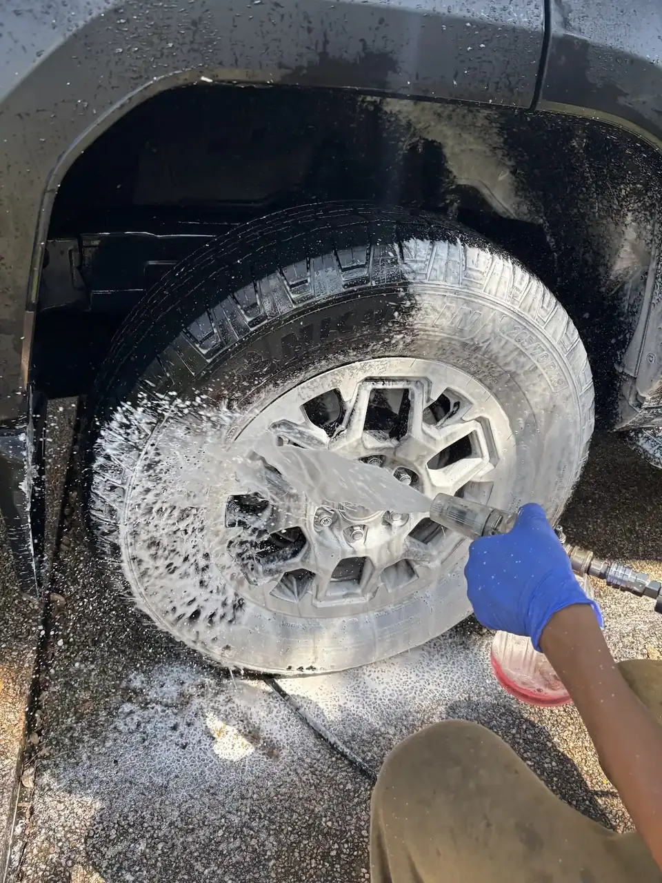 Wheel and tire being scrubbed with cleaning foam