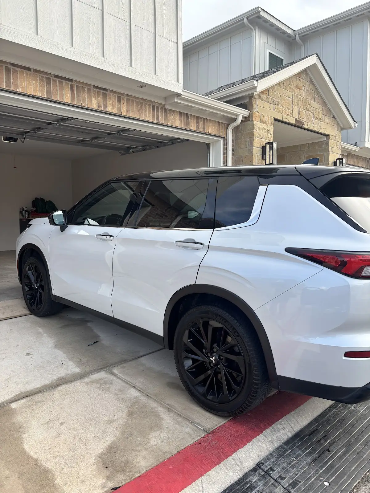 Clean white SUV parked in a driveway after detailing